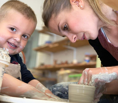 audrey-sur-le-tour-de-potier-avec-son-enfant audrey en train de tourner une tasse